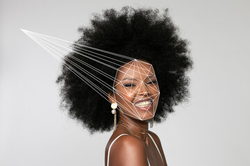 Smiling Afro woman with facial recognition laser beam against white background