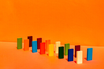 Variation of rectangular construction blocks arranged in a line on orange background