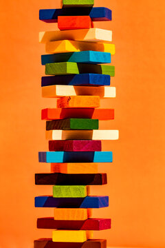 Colorful toy blocks stack against orange background
