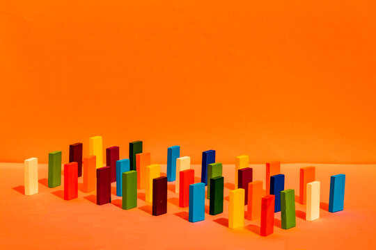 Arrangement of colorful toy blocks in a row on orange background