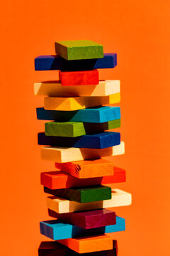 Stack of colorful construction blocks against orange background