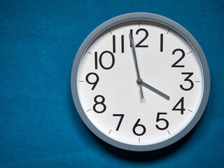 white round analog clock on blue background
