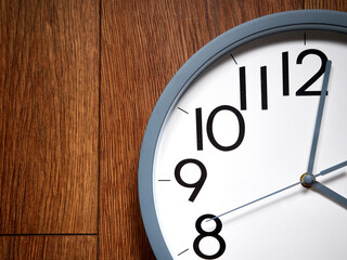 white round analog clock on wooden background