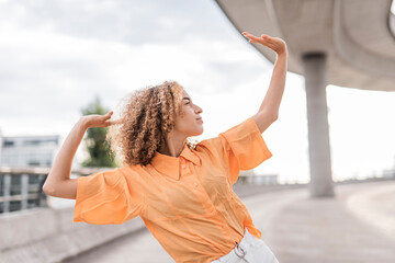 Young woman dancing while standing outdoors