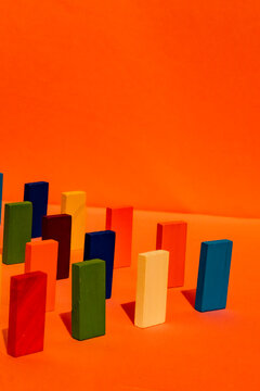 Multi colored rectangular toy block against orange background
