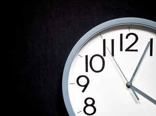 white round analog clock on black background