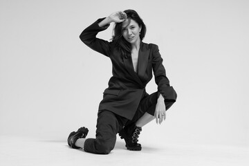 a woman in a business suit sits on a white background