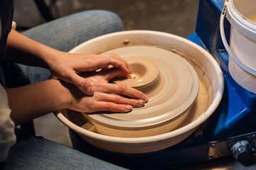 beautiful hands of a young potter's girl in the process of modeling a pot in the workshop