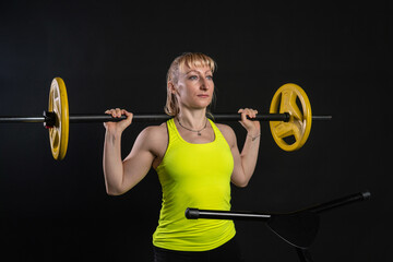 Girl on a fitness trampoline on a black background in a yellow t-shirt trampoline gym sport, equipment activity caucasian workout Fly white motion, athletic muscle instructor enjoy