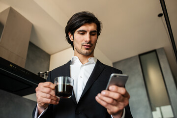 Businessman read news from smartphone while drinking a coffee at home