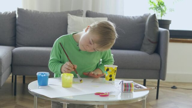 Boy with Down Syndrome drawing at home