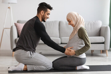 Caring Arab Husband Touching Pregnant Belly Of His Wife In Hijab At Home