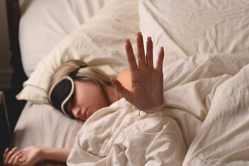 Teenage girl wearing an eye mask in bed wanting to be left alone
