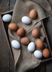 Fresh eggs in a box on old wooden table.
