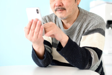 スマホを操作する中高年（シニア）の白髪男性