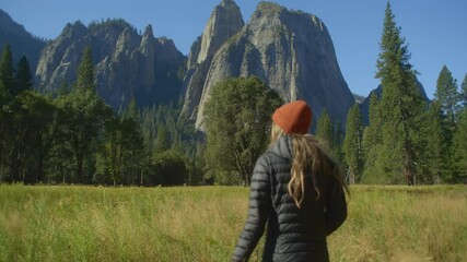 Following Medium Shot of a Young Woman Walking at Yosemite Park on a Sunny Day