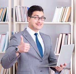 Businessman with a laptop working in the library