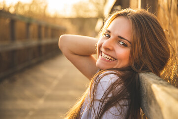 Une jolie brune avec le sourire au coucher du soleil