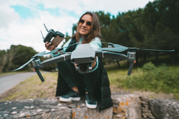 Young beautiful woman pilot with remote control ready to flying a drone