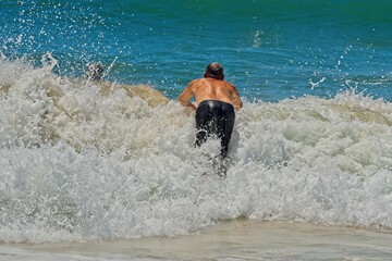 Man jumping into a wave