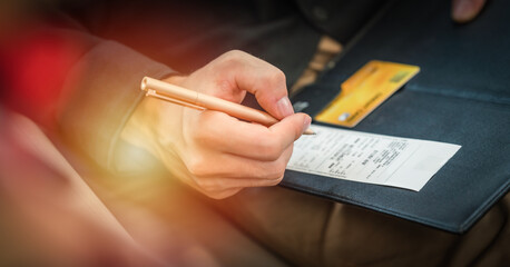 hand holding pen going to sign credit card payment slip at shop