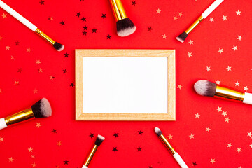 Mockup wooden picture frame top view of cosmetics brushes set for makeup and stars on red background. Cosmetics and beauty concept template Make up concept with copy space flat lay