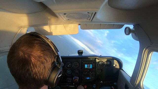 Professional pilot is operating a small plane, turning in the air, landscape