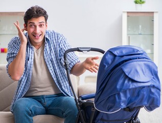 Young father looking after newborn baby at home