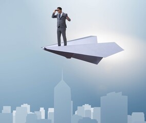 Businessman flying on paper plane in business concept