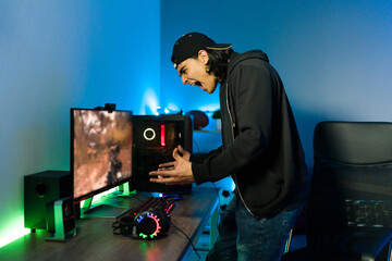 Loser gamer getting upset and shouting in front of a gaming PC © AntonioDiaz