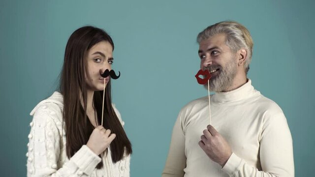 Party props. Photo booth concept. Couple having fun with with fake mustache and lips.