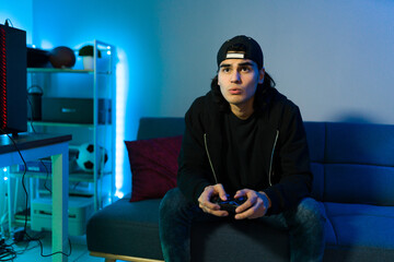 Hispanic man gaming with a remote controller