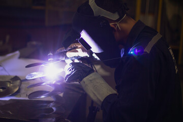 Metal workers use manual labor, Skilled welder, Factory workers making OT. Welder is welding the...