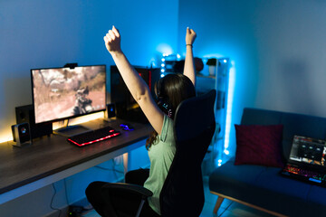 Cheerful young woman rasing her arms and cheering