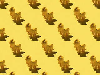 A pattern of yellow pony toys on a yellow background.