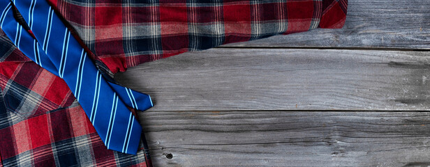 Plaid shirt with blue necktie on vintage wooden planks for Fathers Day