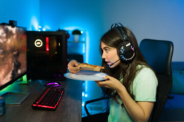 Woman gamer enjoying dinner while gaming on her computer © AntonioDiaz