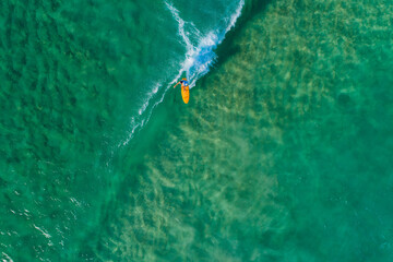 Surfer from above clean water riding waves