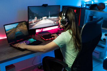Professional female gamer playing with a PC and a laptop © AntonioDiaz