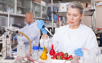 Professional female geneticist working in laboratory, conducting experiments with genetically...