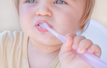 Close-up, the baby is brushing his teeth.