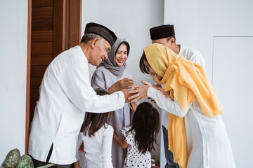 portrait of happy asian muslim family visiting grandparents on ramadan kareem. indonesian people...