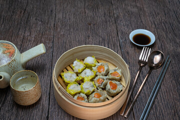 Chinese Steamed dumplings with sauce on  wooden background are ready to serve and eat.
