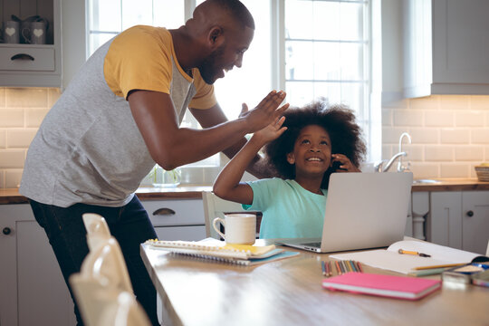 African american girl using laptop with her father