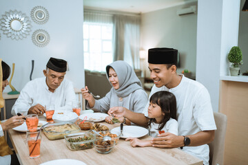 beautiful asian family enjoying their iftar dinner at home. ramadan kareem islam break fasting tradition