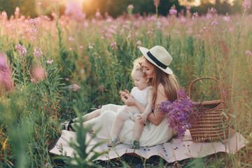 a happy family walks through a flower meadow. Love and spring blooming. Mother with daughter...