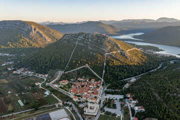 Aerial drone shot of Ston city wall over hill in Ragusa region near Dubrovnik in Croatia summer sunrise