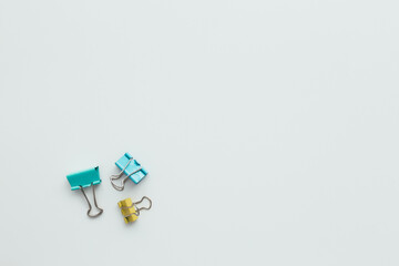 Blue and yellow paper clips on white background. Work and education concept