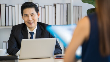 Unrecognizable male job recruiter typing on laptop before interview with female candidate