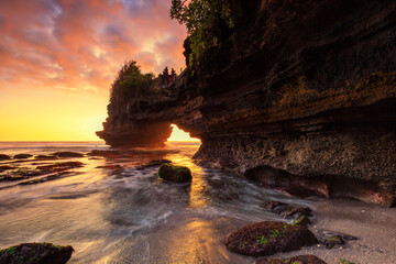 Dramatic Sunset color at Batu Bolong temple and Tanah Lot, Tabanan, Bali. beautiful view with the coral reef in low tide.